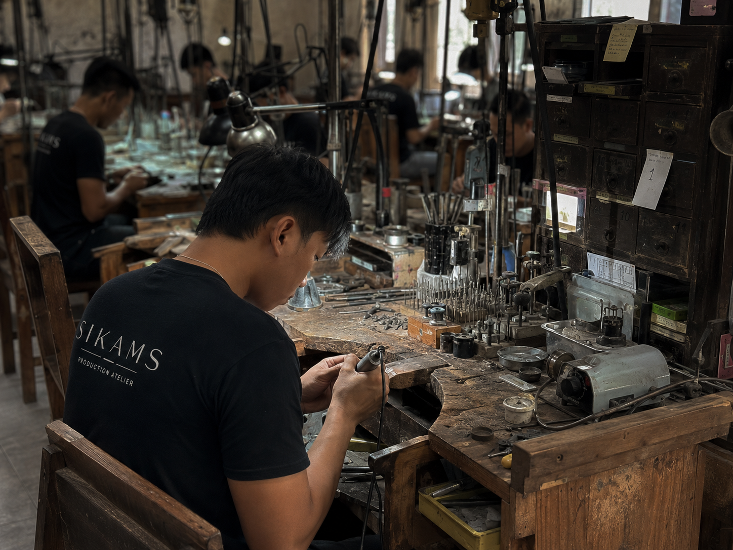 Jeweler's hands filing a silver signet at the workbench